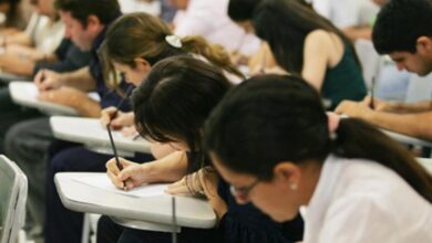 Candidata prestando atenção em edital de concurso público
