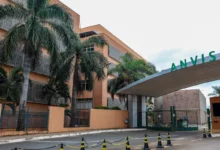 Frasco de medicamento e instalações da Anvisa em destaque