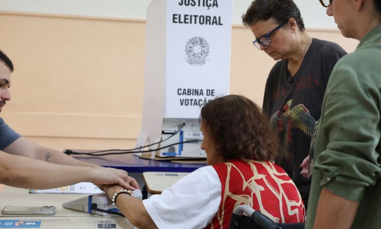 Idoso utilizando urna eletrônica durante votação